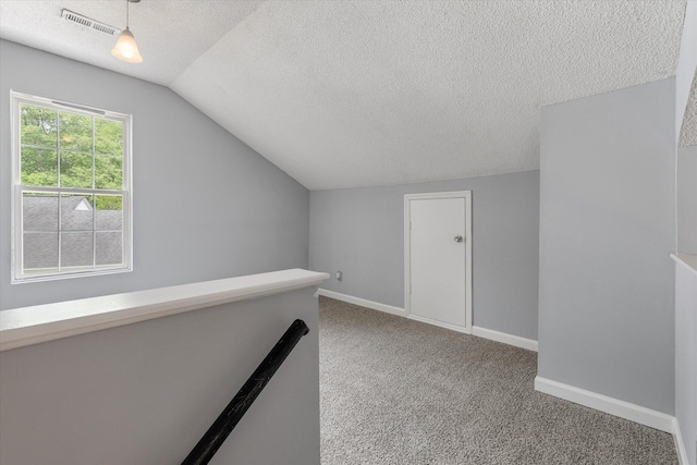 bonus room featuring vaulted ceiling, a textured ceiling, carpet, and baseboards