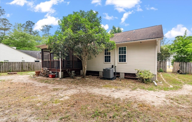 back of property featuring central air condition unit, fence, and a sunroom