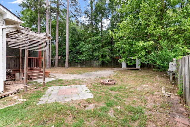 fenced backyard featuring an outdoor fire pit, a storage shed, and an outbuilding