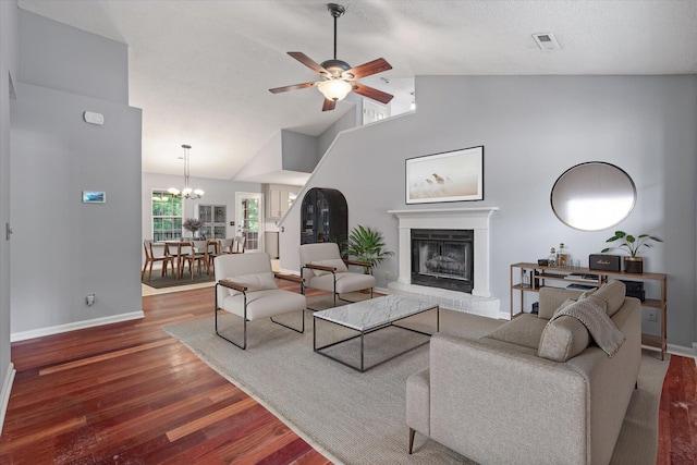living room with wood finished floors, baseboards, a fireplace, a ceiling fan, and high vaulted ceiling