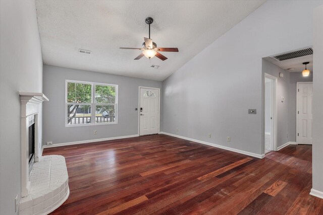 unfurnished living room with ceiling fan, wood finished floors, a brick fireplace, baseboards, and high vaulted ceiling