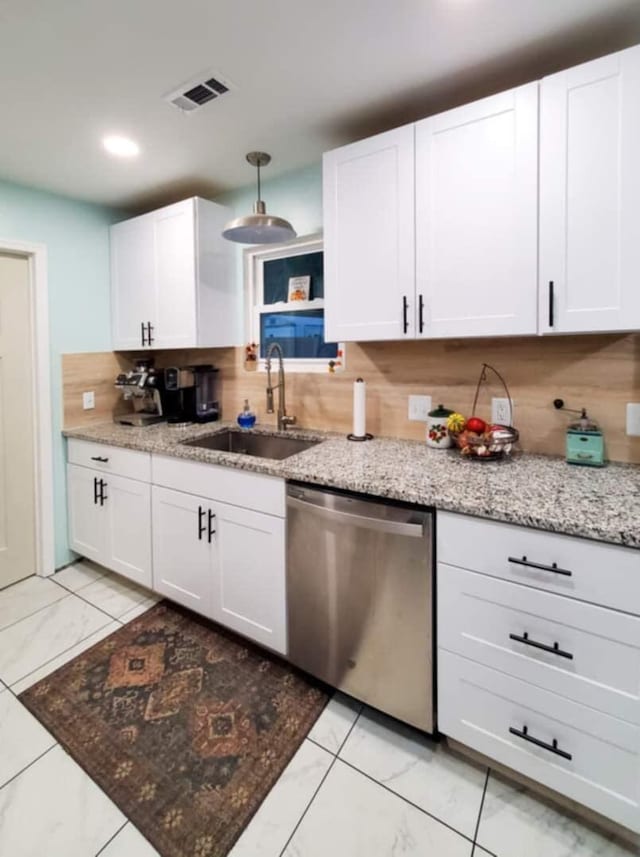 kitchen featuring sink, tasteful backsplash, light stone counters, stainless steel dishwasher, and white cabinets