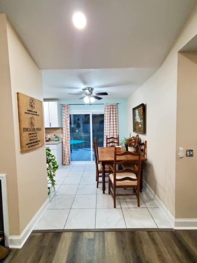 dining space with ceiling fan and light wood-type flooring