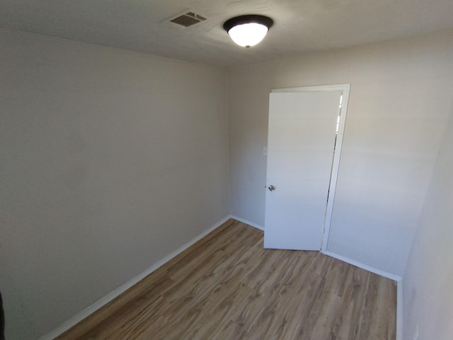 spare room featuring wood finished floors and baseboards