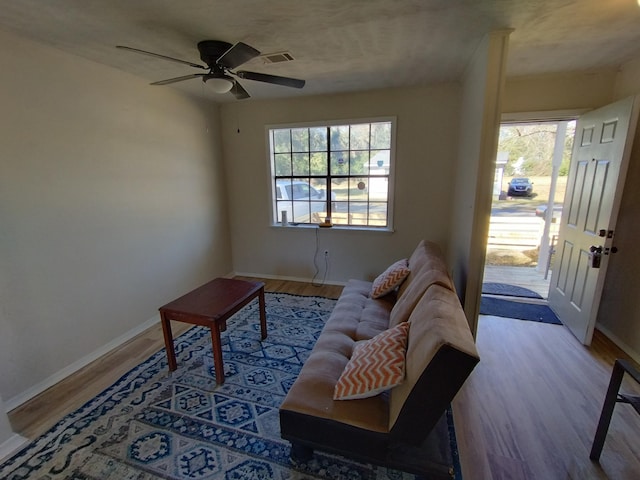 living area with wood finished floors, baseboards, and a ceiling fan