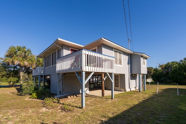 rear view of house with a lawn, a patio area, a sunroom, and a deck