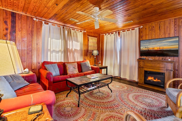 living room with a wealth of natural light, wooden ceiling, and wooden walls