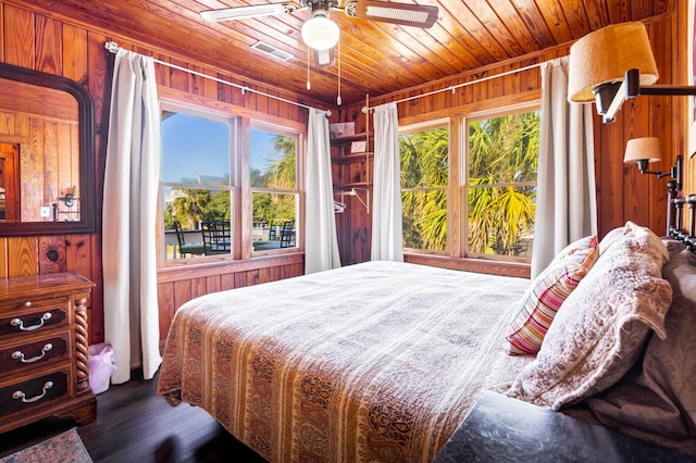 bedroom with wood walls, dark hardwood / wood-style floors, ceiling fan, and wooden ceiling