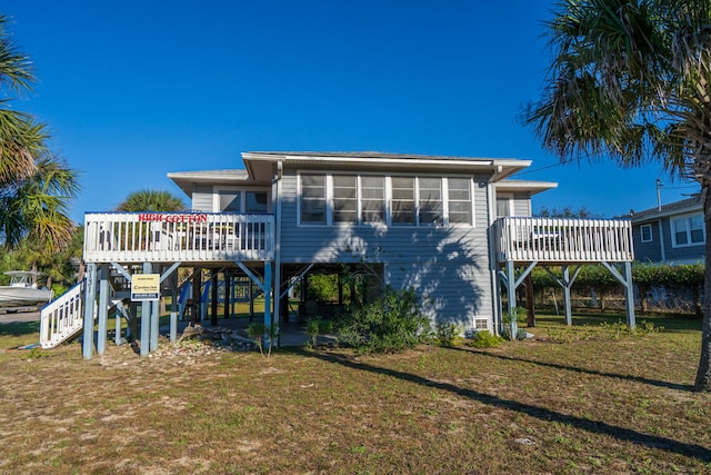 rear view of house with a lawn and a deck