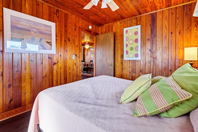 bedroom featuring ceiling fan, wood-type flooring, wooden ceiling, and wooden walls