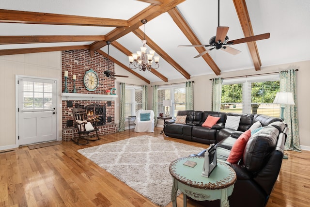 living room featuring light hardwood / wood-style flooring, vaulted ceiling with beams, a fireplace, and plenty of natural light