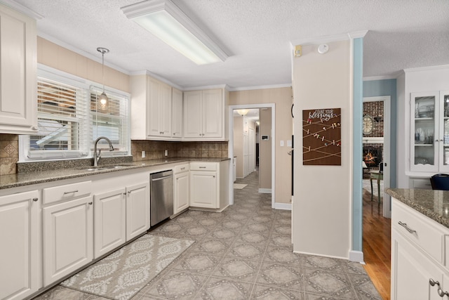 kitchen featuring dishwasher, backsplash, ornamental molding, sink, and white cabinets