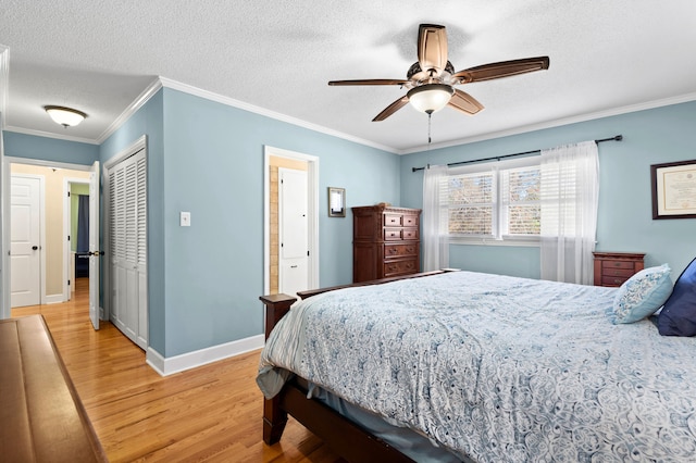 bedroom featuring light hardwood / wood-style floors, ornamental molding, a textured ceiling, and ceiling fan