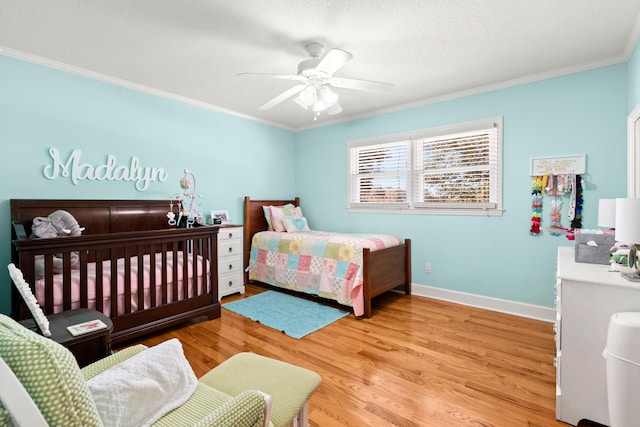 bedroom featuring light hardwood / wood-style floors, ornamental molding, a textured ceiling, and ceiling fan