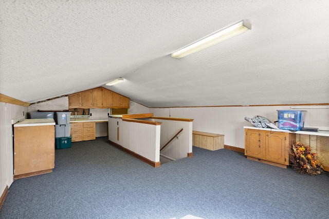 bonus room with a textured ceiling, dark carpet, and vaulted ceiling