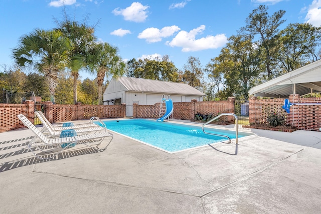 view of swimming pool featuring a patio and a water slide