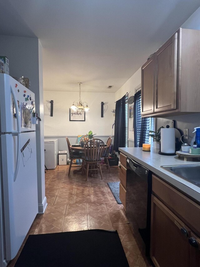 527 Travelers Blvd, Summerville, SC 29485 - kitchen with freestanding refrigerator, black dishwasher, a chandelier, decorative light fixtures, and dark brown cabinetry