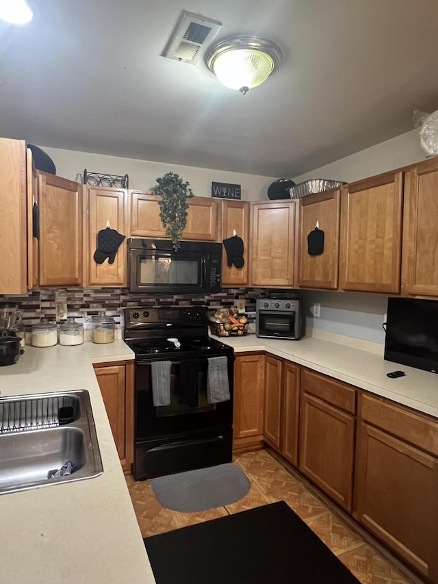 527 Travelers Blvd, Summerville, SC 29485 - kitchen featuring black appliances, light countertops, a sink, backsplash, and brown cabinetry