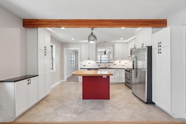 kitchen with decorative backsplash, beam ceiling, white cabinets, wood counters, and stainless steel appliances