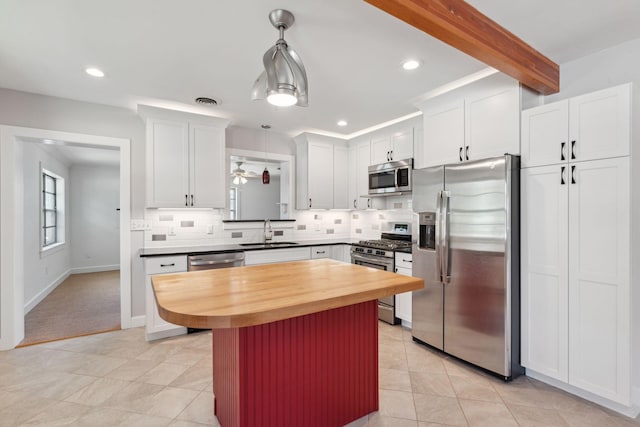 kitchen featuring a sink, backsplash, stainless steel appliances, and white cabinetry