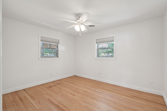 empty room featuring a healthy amount of sunlight, baseboards, and light wood-style flooring