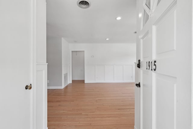 corridor featuring recessed lighting, a wainscoted wall, light wood finished floors, and visible vents