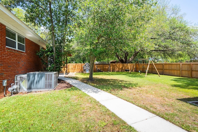 view of yard featuring a fenced backyard, an outbuilding, central AC, and a storage shed