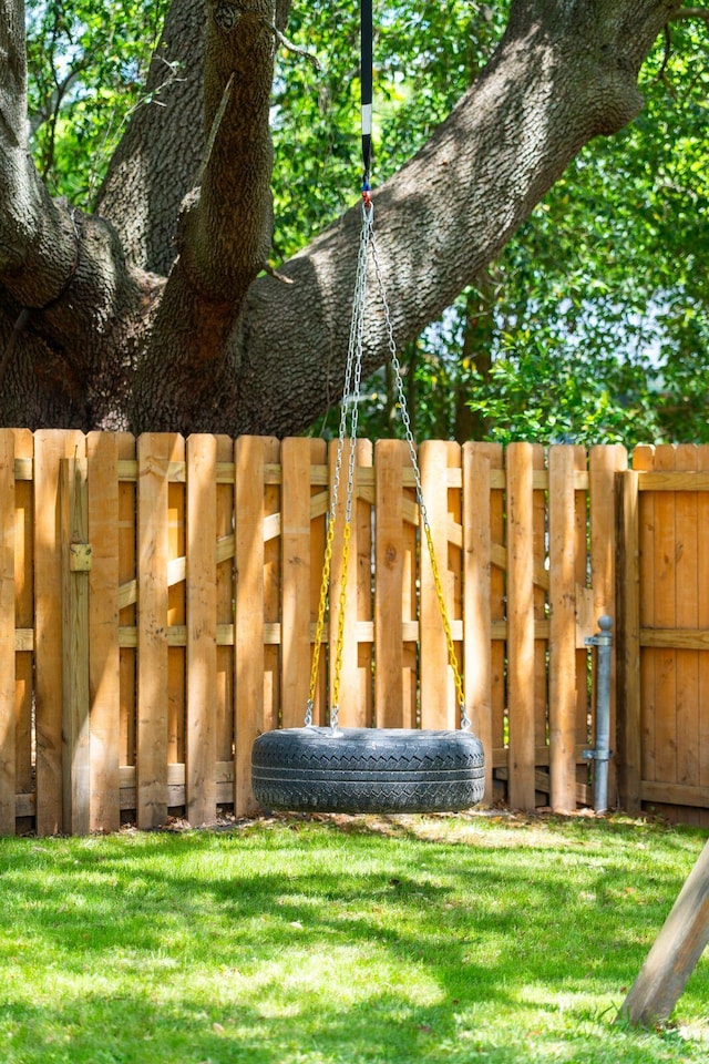 view of gate with a lawn and fence
