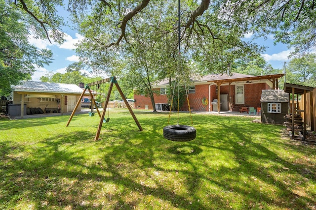 view of yard with an outdoor structure, a fenced backyard, a playground, a patio, and a fire pit
