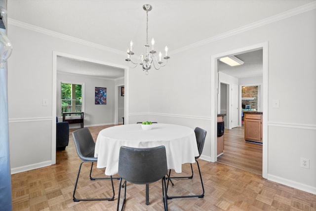 dining area with crown molding, baseboards, and a chandelier