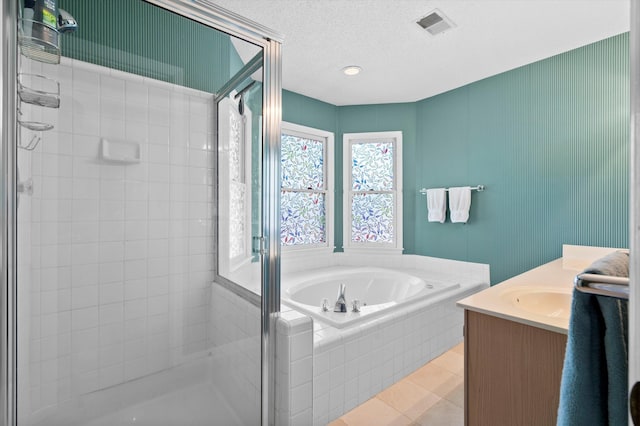 full bathroom featuring vanity, a shower stall, a garden tub, and visible vents