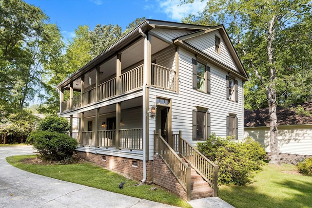 view of front of property featuring crawl space, a balcony, and a front yard