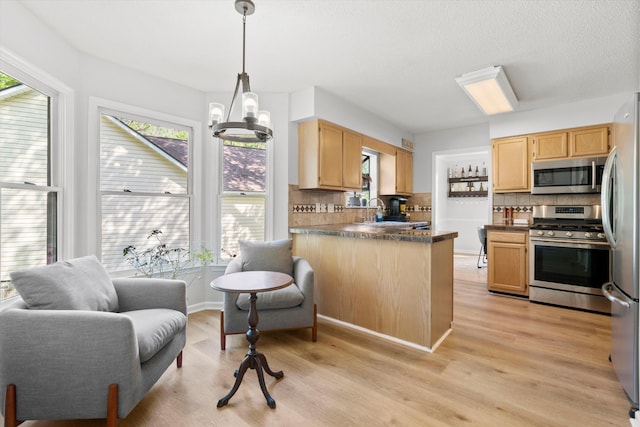 kitchen featuring backsplash, stainless steel appliances, dark countertops, and a healthy amount of sunlight