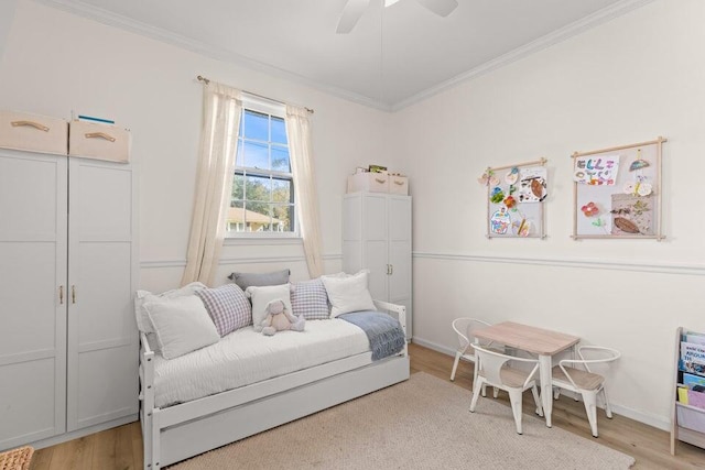 bedroom featuring ornamental molding, ceiling fan, and light wood-type flooring