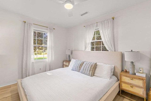 bedroom with multiple windows, ceiling fan, and light wood-type flooring