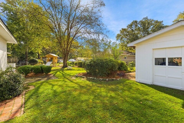 view of yard with a garage and a playground