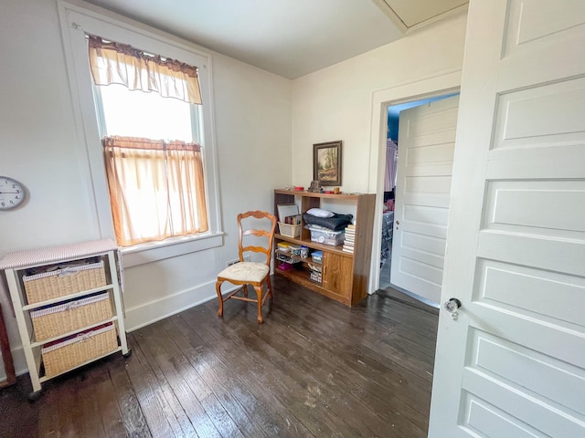 living area with a healthy amount of sunlight, heating unit, and dark wood-type flooring