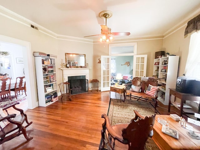 living room featuring hardwood / wood-style flooring, ceiling fan, ornamental molding, and french doors