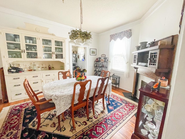 dining area with light hardwood / wood-style flooring and crown molding