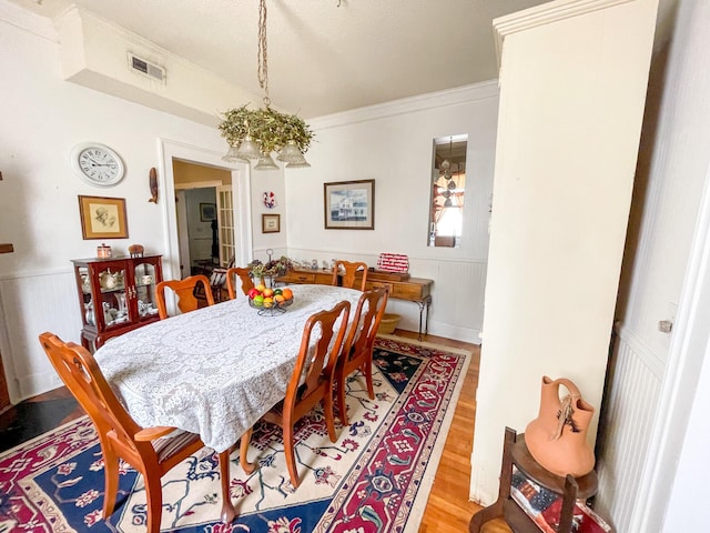 dining room featuring light wood-type flooring and crown molding