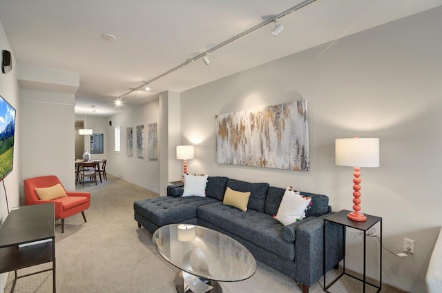 carpeted living room featuring track lighting