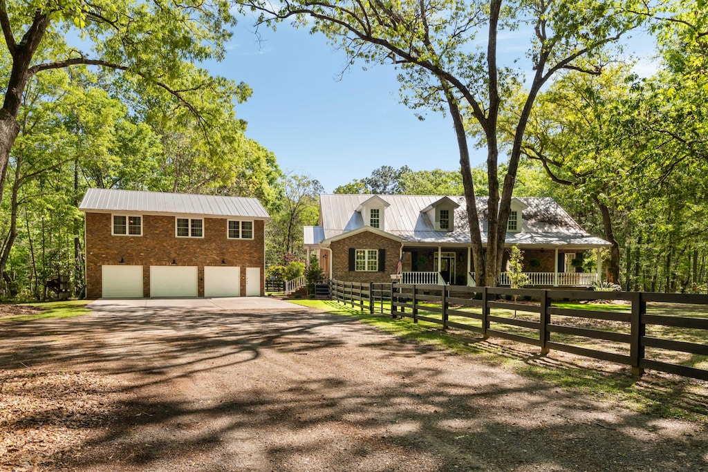 5680 Dixie Plantation Rd, Hollywood, SC 29449 - view of front of property featuring metal roof, brick siding, a fenced front yard, and dirt driveway