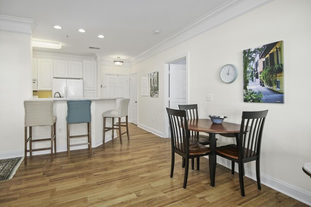 living room with light hardwood / wood-style floors, crown molding, and ceiling fan