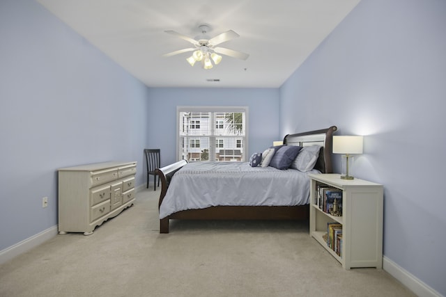 bedroom featuring light colored carpet, ceiling fan, visible vents, and baseboards