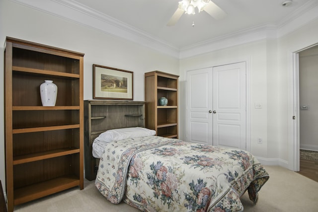 bedroom featuring carpet flooring, a ceiling fan, baseboards, ornamental molding, and a closet