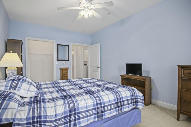 bedroom featuring ceiling fan, light carpet, and connected bathroom