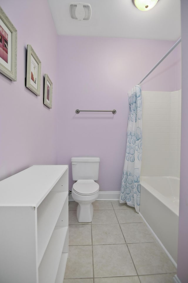 full bath featuring shower / bath combo with shower curtain, tile patterned flooring, toilet, and baseboards