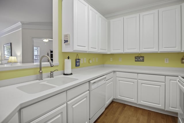 kitchen with dishwasher, ornamental molding, a sink, and white cabinetry