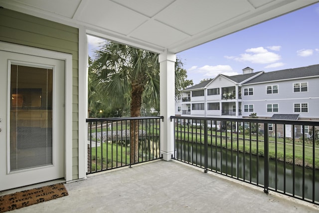 balcony with a residential view and a water view