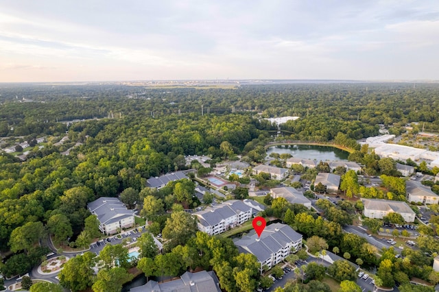 drone / aerial view featuring a water view and a forest view